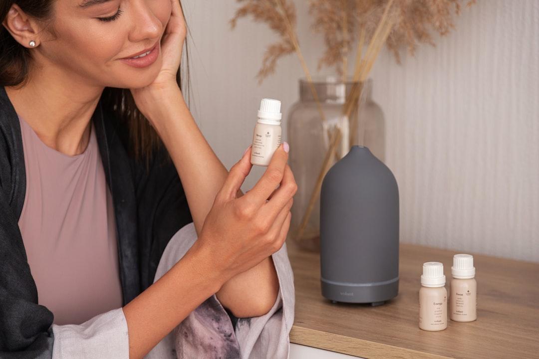 A woman sitting on a table holding a bottle of lotion 5amkndk5x34.jpeg